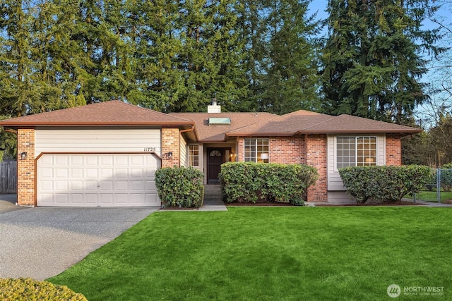 ranch-style home with brick siding, an attached garage, driveway, and a front lawn