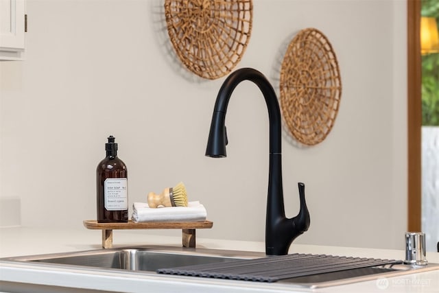 room details featuring a sink and white cabinetry