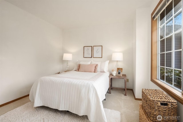 bedroom featuring multiple windows, baseboards, and carpet