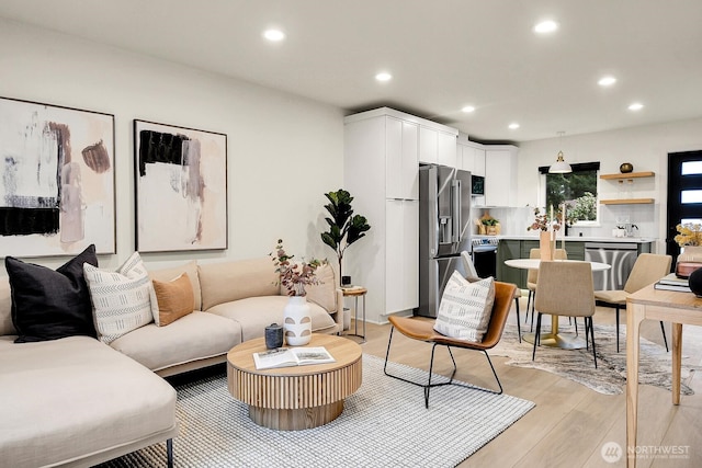 living room with light wood-style flooring and recessed lighting