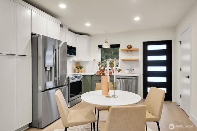 kitchen with white cabinetry, recessed lighting, light wood-type flooring, and appliances with stainless steel finishes