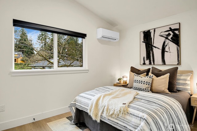 bedroom with multiple windows, a wall mounted air conditioner, light wood-style floors, and lofted ceiling