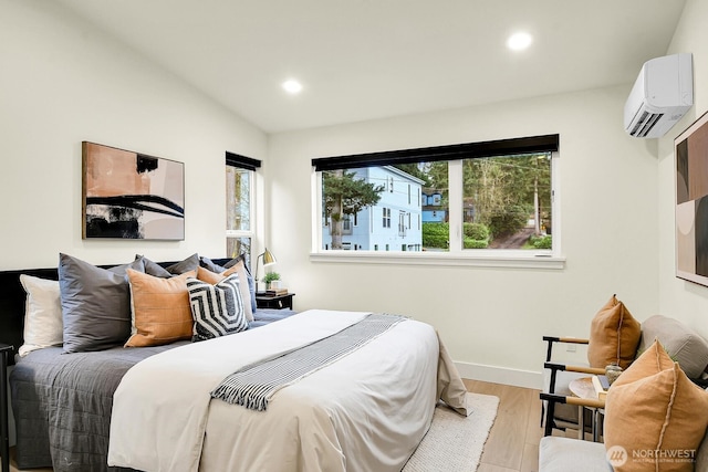 bedroom featuring recessed lighting, an AC wall unit, baseboards, and wood finished floors