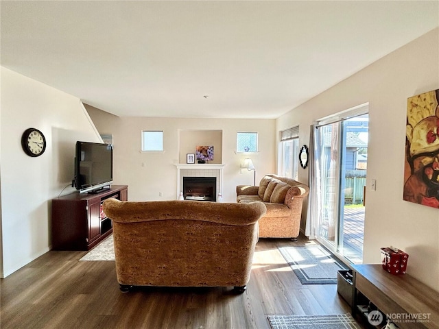 living room with dark wood-style floors and a tile fireplace