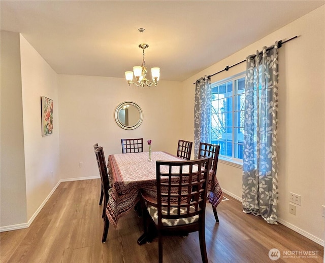 dining room featuring baseboards, an inviting chandelier, and wood finished floors