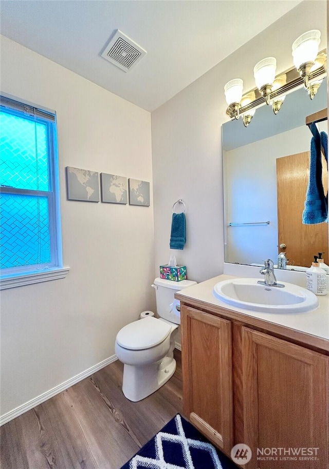 bathroom with vanity, wood finished floors, visible vents, an inviting chandelier, and toilet