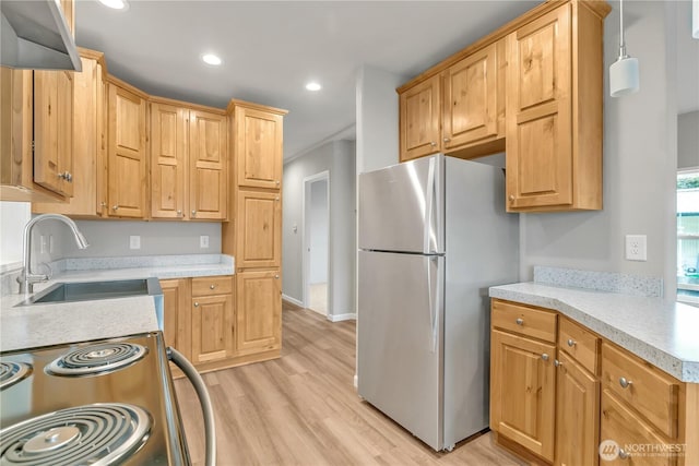 kitchen featuring light countertops, freestanding refrigerator, electric range oven, and a sink