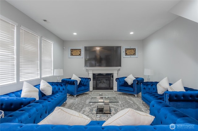 living room featuring recessed lighting, visible vents, and a glass covered fireplace