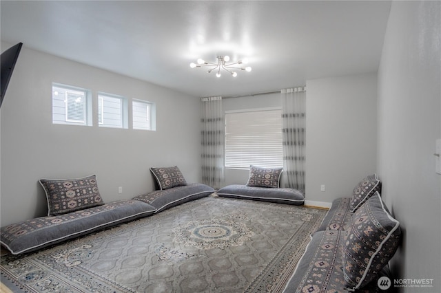 sitting room featuring an inviting chandelier and baseboards