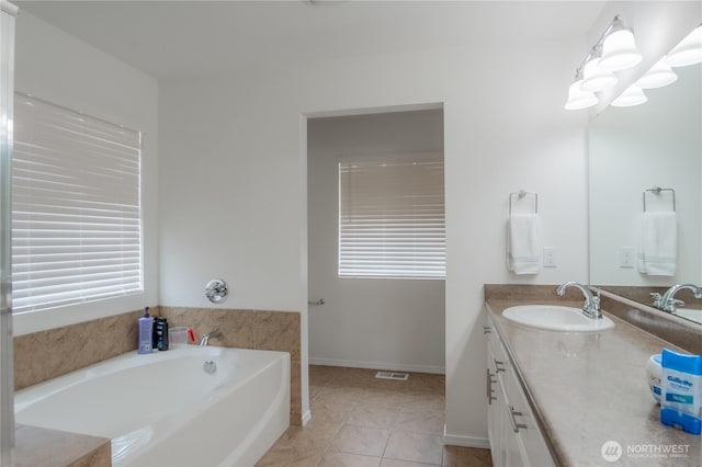 full bathroom with visible vents, a garden tub, tile patterned flooring, baseboards, and vanity