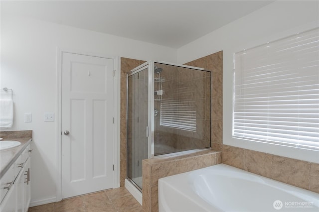 full bathroom with tile patterned floors, a garden tub, a stall shower, and vanity