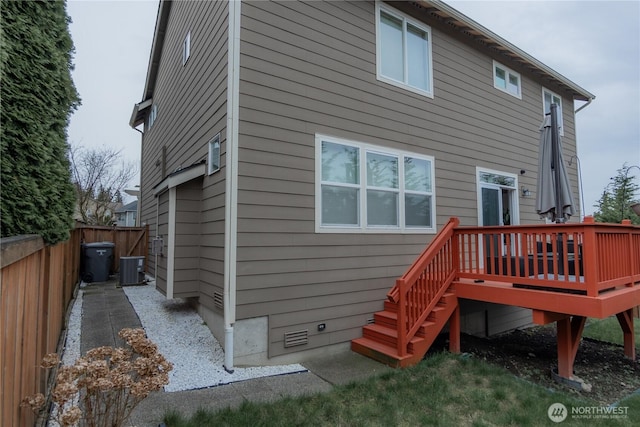 back of house with crawl space, cooling unit, a deck, and fence