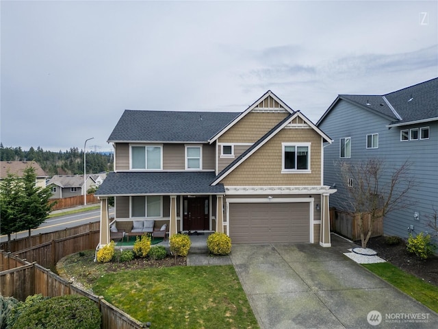 view of front of home with a garage, covered porch, driveway, and fence