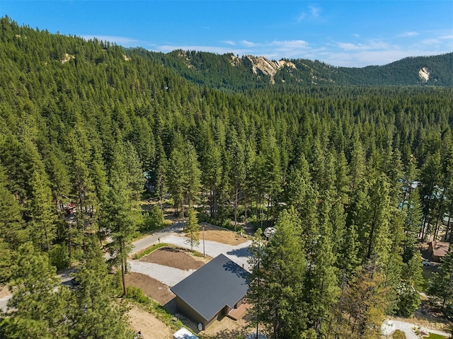 birds eye view of property featuring a mountain view and a wooded view