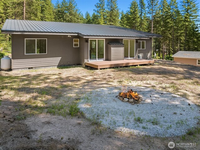 rear view of house with crawl space, metal roof, a deck, and a standing seam roof