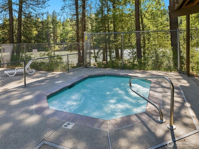 view of pool with a swimming pool and fence