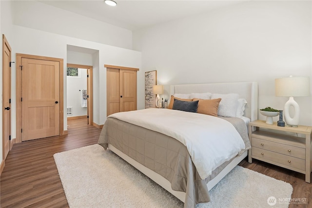 bedroom with baseboards, visible vents, recessed lighting, dark wood-type flooring, and a closet