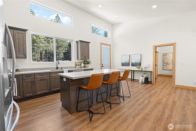 kitchen featuring light countertops, a kitchen island, light wood finished floors, and stainless steel refrigerator