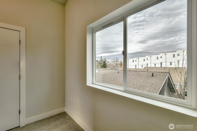 carpeted spare room with baseboards