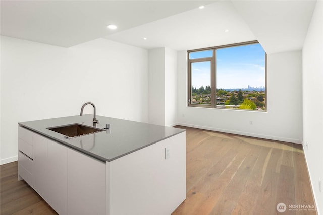 10232 NE 10th St Unit 1015, Bellevue, WA 98004 - kitchen featuring white cabinets, light wood finished floors, a center island with sink, modern cabinets, and recessed lighting