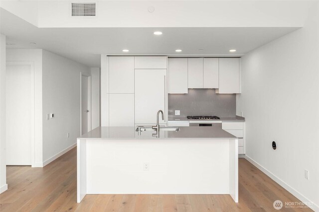 10232 NE 10th St Unit 1015, Bellevue, WA 98004 - kitchen featuring white cabinetry, modern cabinets, light wood-style floors, stainless steel gas stovetop, and a center island with sink