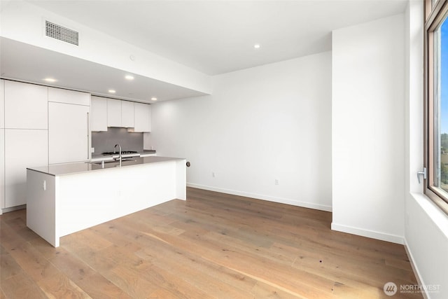 10232 NE 10th St Unit 1015, Bellevue, WA 98004 - kitchen featuring modern cabinets, white cabinets, light wood-style floors, recessed lighting, and decorative backsplash