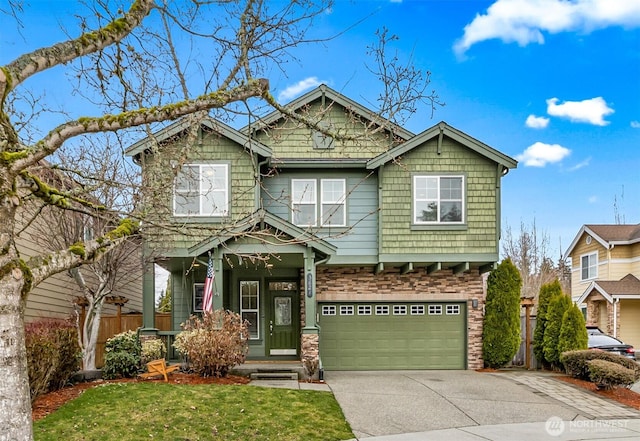 craftsman-style home with a front lawn, stone siding, fence, concrete driveway, and a garage