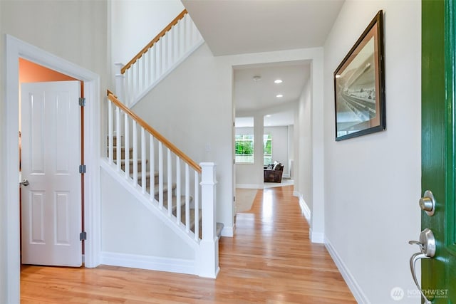 entrance foyer with light wood finished floors, stairway, recessed lighting, and baseboards