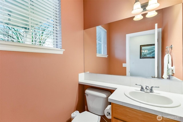 bathroom with toilet, vanity, and an inviting chandelier