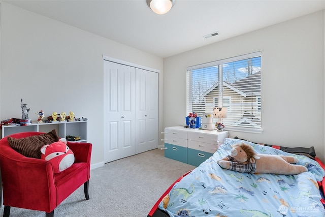 bedroom with light colored carpet, visible vents, a closet, and baseboards