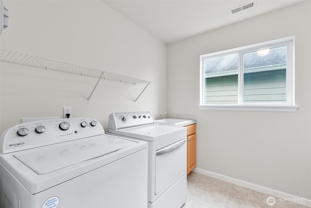 laundry area with visible vents, baseboards, cabinet space, a sink, and washing machine and dryer