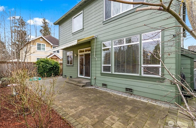 back of property with crawl space, a patio area, and fence