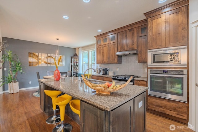 16103 NE 102nd Way, Vancouver, WA 98682 - kitchen with appliances with stainless steel finishes, backsplash, wood finished floors, light stone counters, and recessed lighting