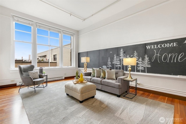 living room featuring a baseboard heating unit and wood finished floors