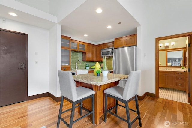 dining room featuring light wood finished floors, recessed lighting, and baseboards