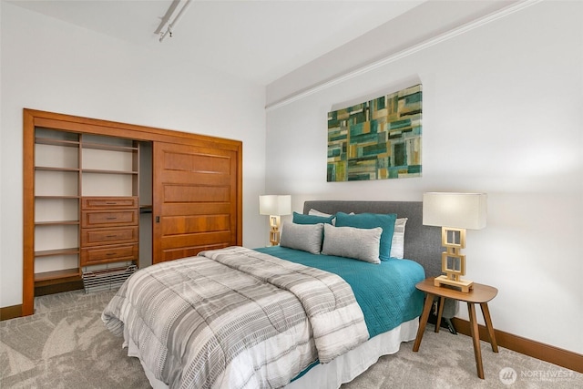 bedroom with rail lighting, carpet, and baseboards