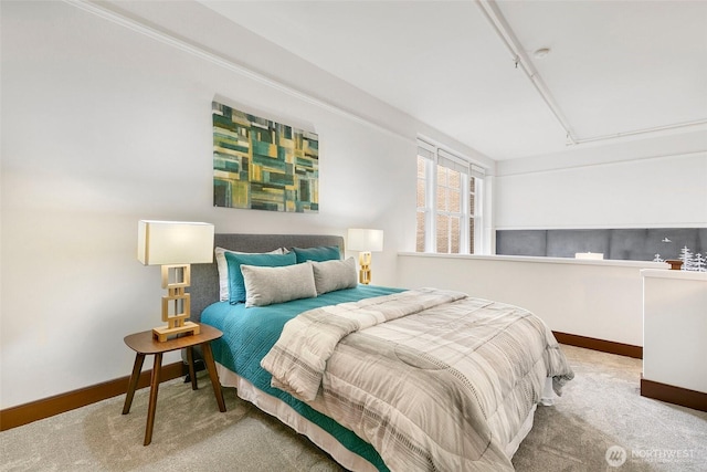 bedroom with baseboards, carpet floors, and attic access