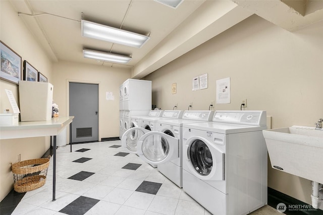 shared laundry area with a sink, visible vents, stacked washer / drying machine, and washing machine and clothes dryer