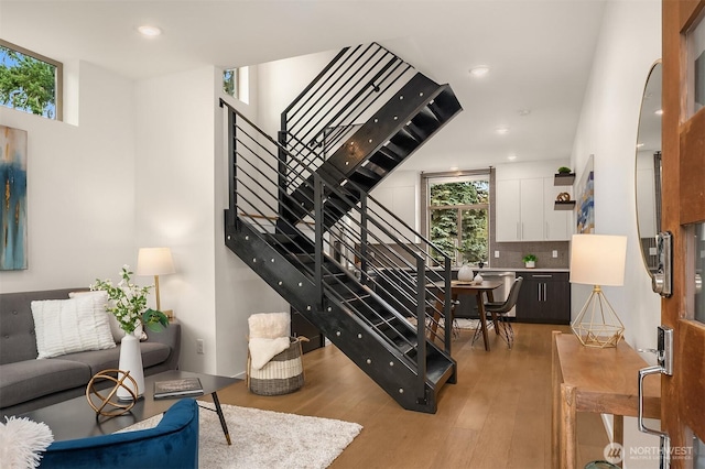 staircase with recessed lighting and wood finished floors