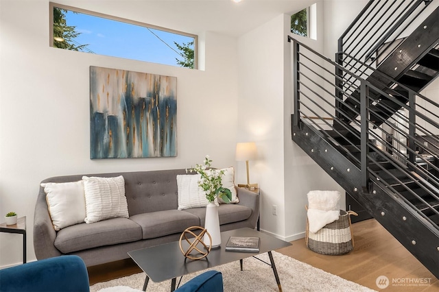 living room featuring stairs, wood finished floors, and baseboards