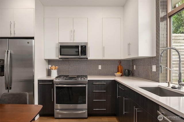 kitchen with light countertops, white cabinets, tasteful backsplash, and stainless steel appliances