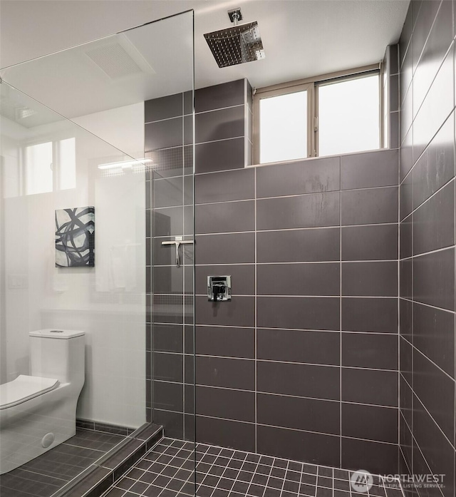 bathroom with toilet and tiled shower