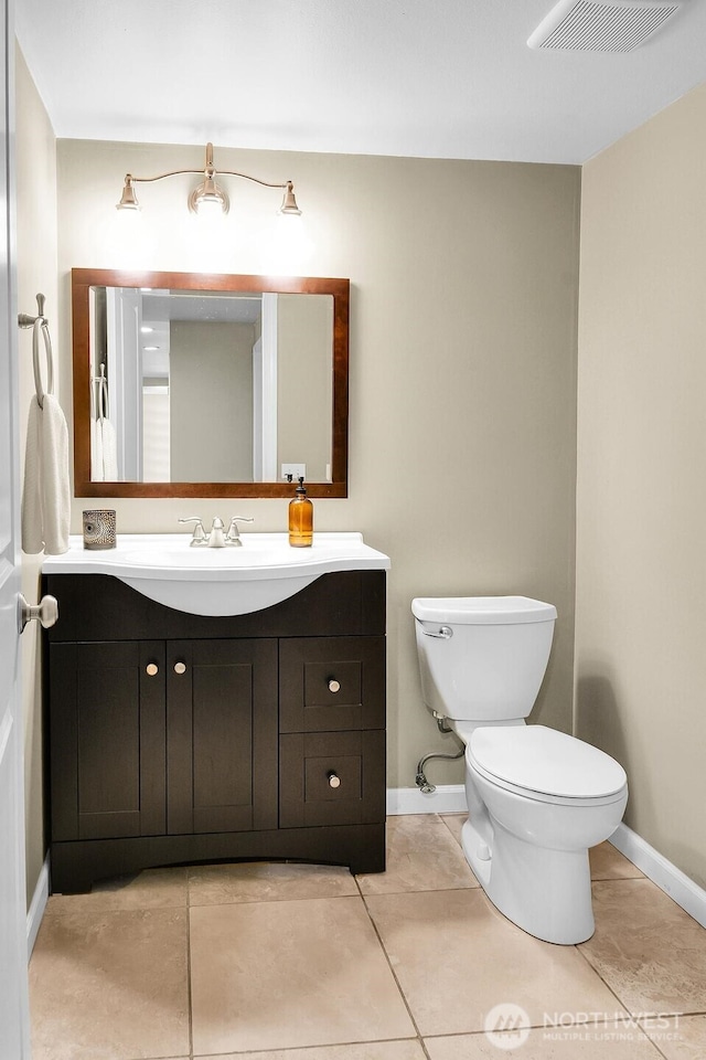 bathroom featuring visible vents, toilet, vanity, and baseboards