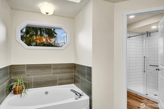 bathroom with a shower stall and a bath