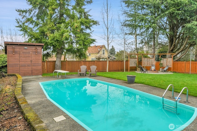 view of swimming pool featuring a patio, an outbuilding, a fenced backyard, a diving board, and a lawn