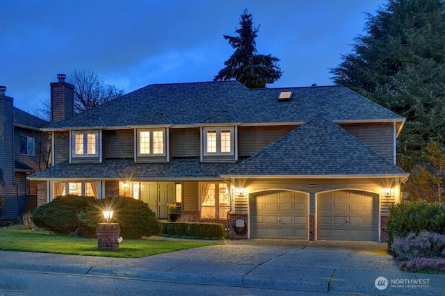 view of front of home with a garage, driveway, and a shingled roof