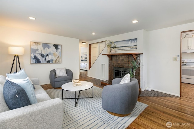 living room with recessed lighting, baseboards, wood finished floors, and a tiled fireplace