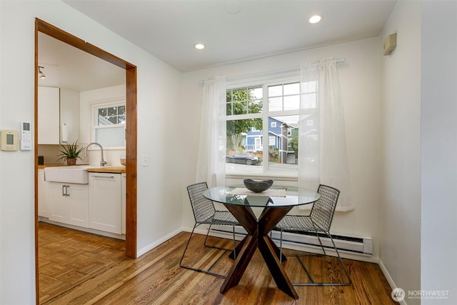 dining space featuring a baseboard heating unit, parquet flooring, recessed lighting, and baseboards