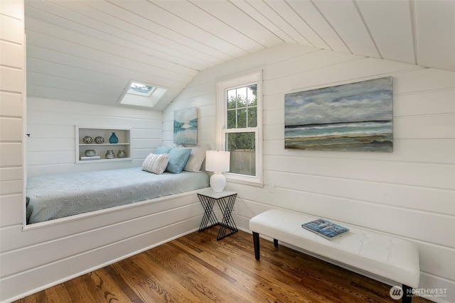 bedroom featuring lofted ceiling with skylight, wooden walls, and dark wood-style flooring