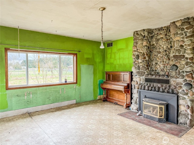 living area featuring a wood stove, baseboards, and visible vents